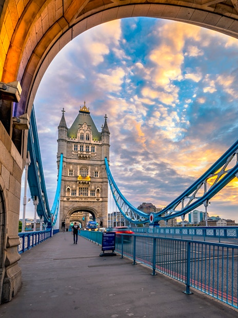 Tower Bridge in London at sunset, viewed from under an archway.