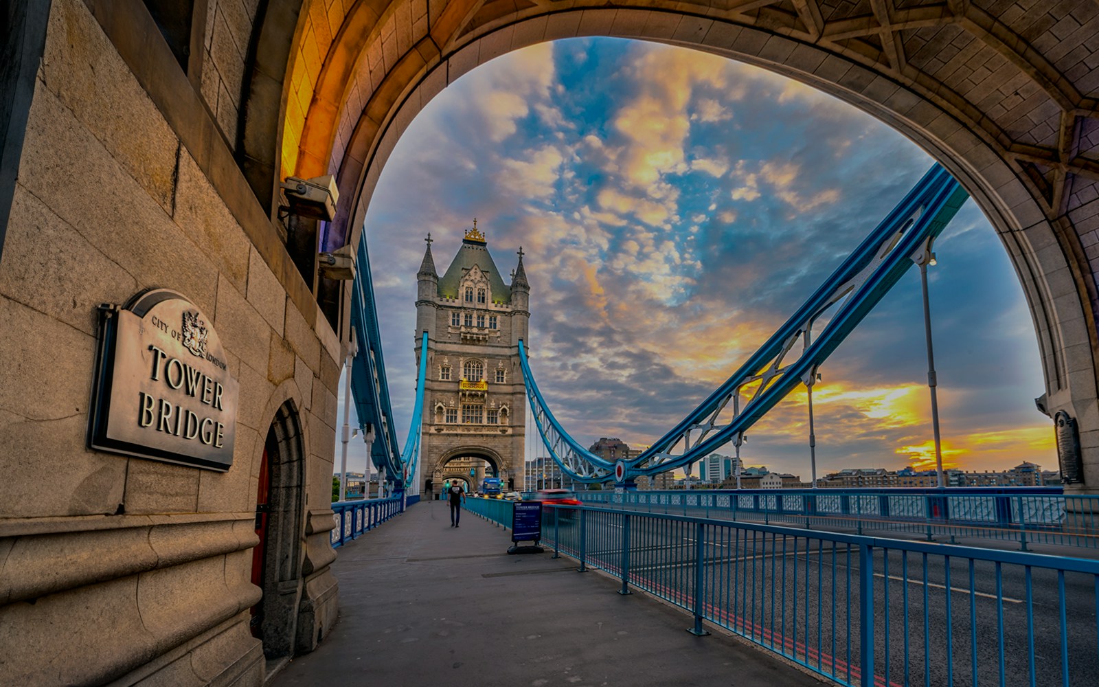 Tower Bridge in London at sunset, viewed from under an archway.
