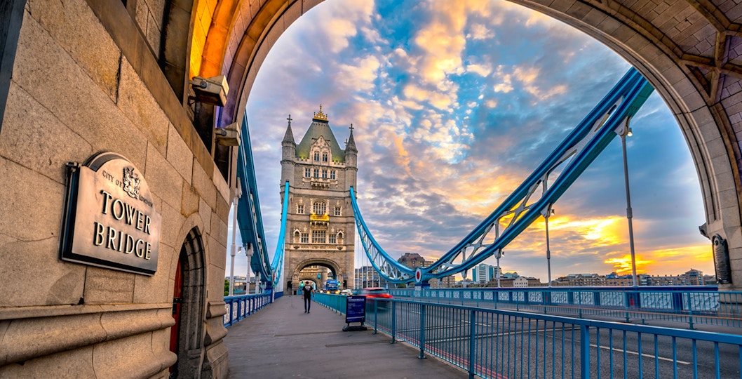 Tower Bridge in London at sunset, viewed from under an archway.
