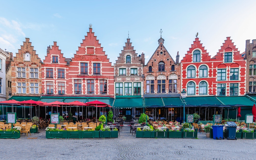 Historic gabled buildings and outdoor cafes at Markt, Market Square in Bruges.