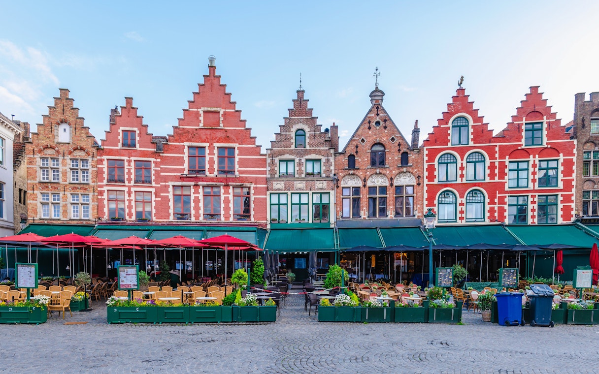Historic gabled buildings and outdoor cafes at Markt, Market Square in Bruges.