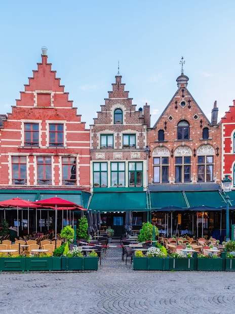 Historic gabled buildings and outdoor cafes at Markt, Market Square in Bruges.