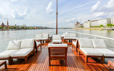 Outer deck seating area on Elegant Premium Sightseeing Cruise with cityscape views.