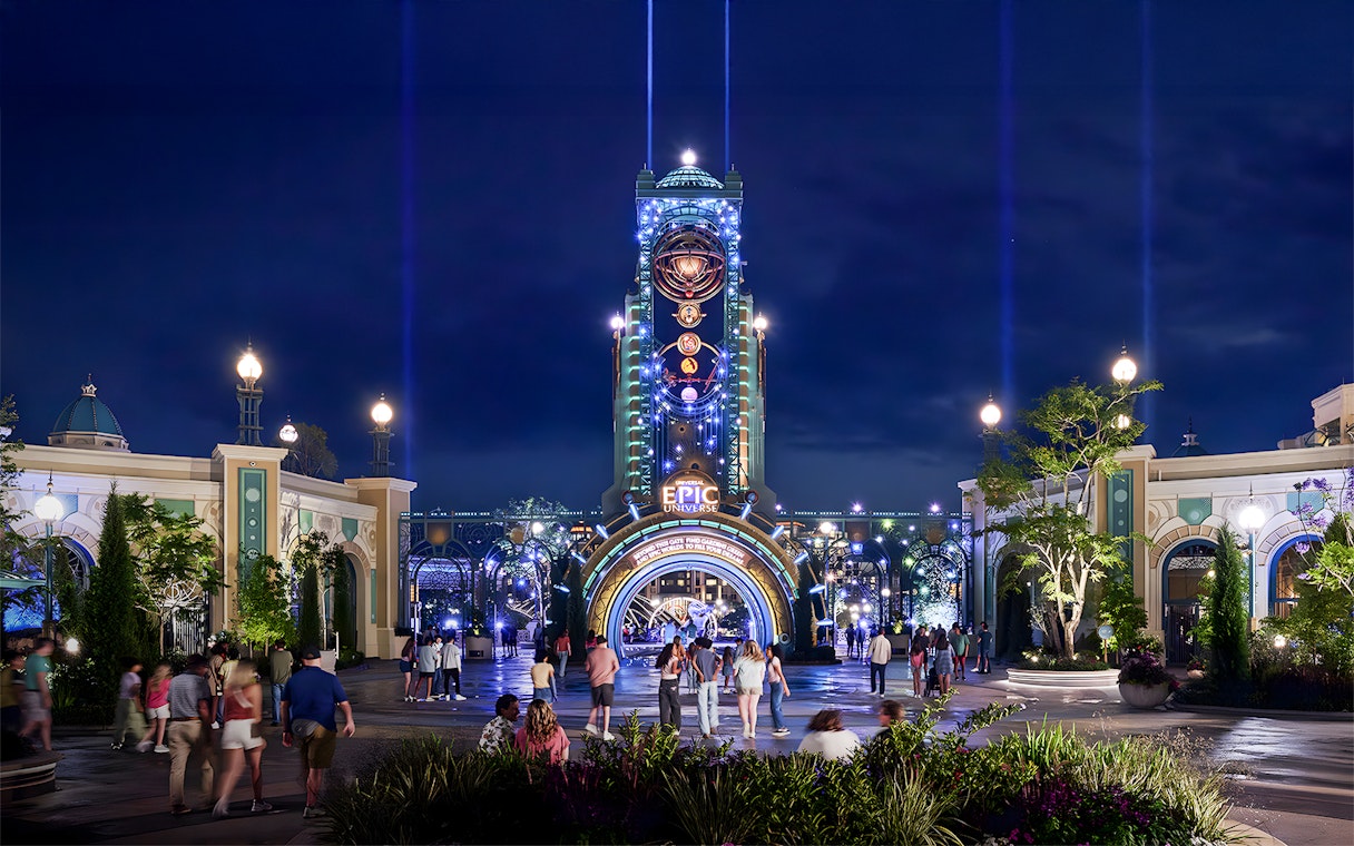 Guests entering Epic Universe park entrance at night, Universal Orlando, Florida.