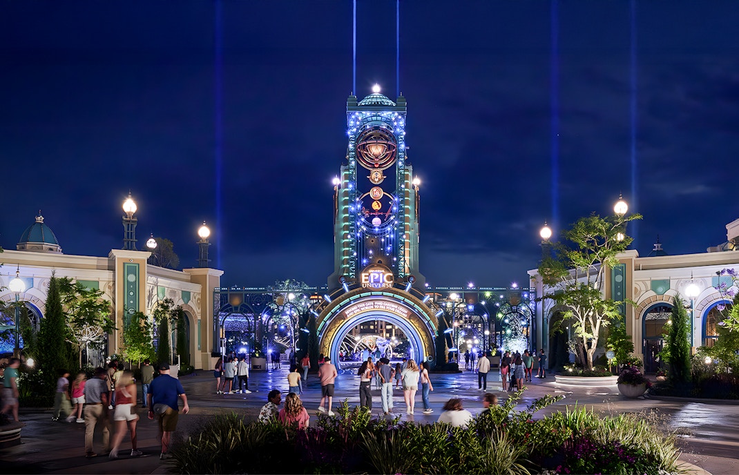 Guests entering Epic Universe park entrance at night, Universal Orlando, Florida.