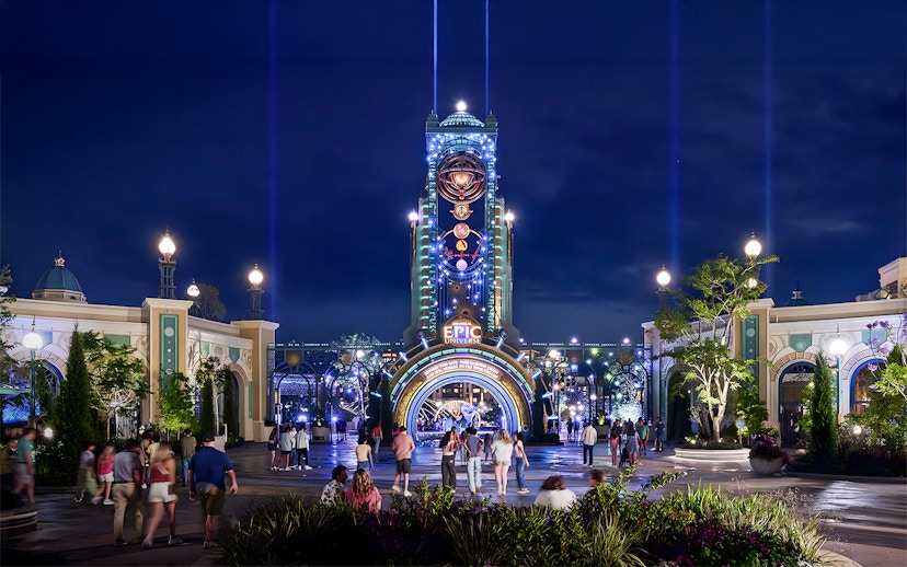 Guests entering Epic Universe park entrance at night, Universal Orlando, Florida.