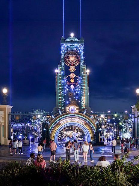 Guests entering Epic Universe park entrance at night, Universal Orlando, Florida.