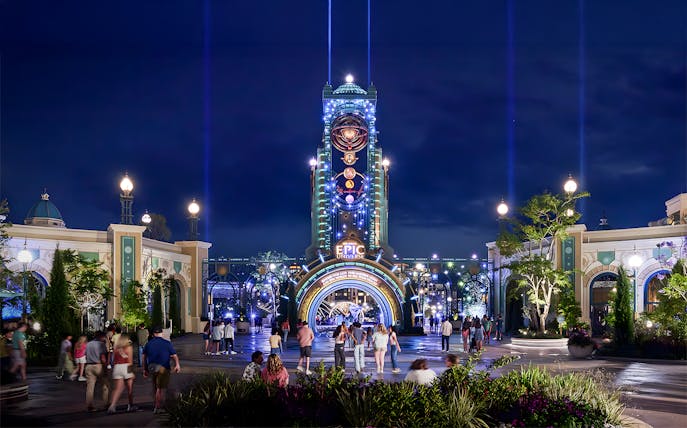 Guests entering Epic Universe park entrance at night, Universal Orlando, Florida.