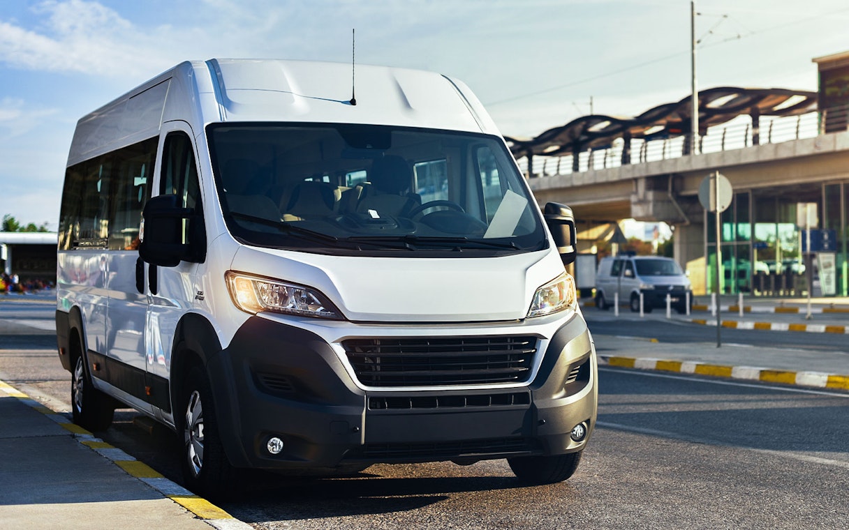 Minivan for airport transfer parked near terminal.