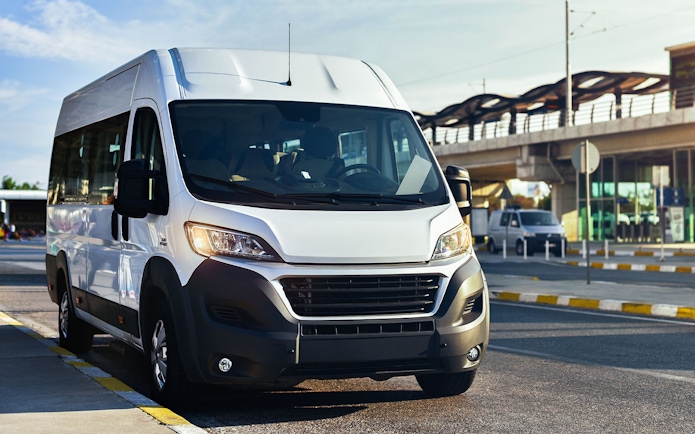Minivan for airport transfer parked near terminal.