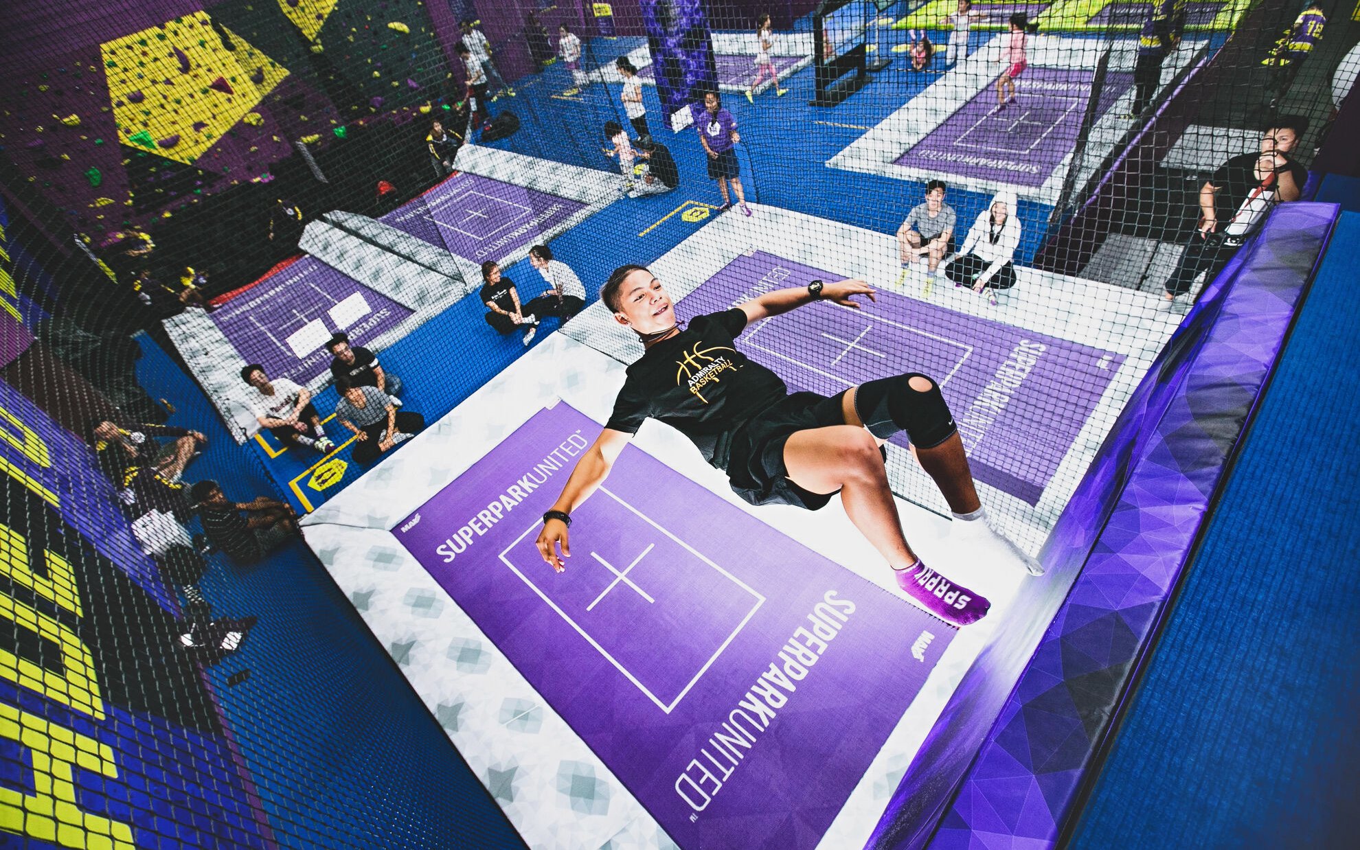 Woman jumping on trampoline at SuperPark Singapore indoor activity center.