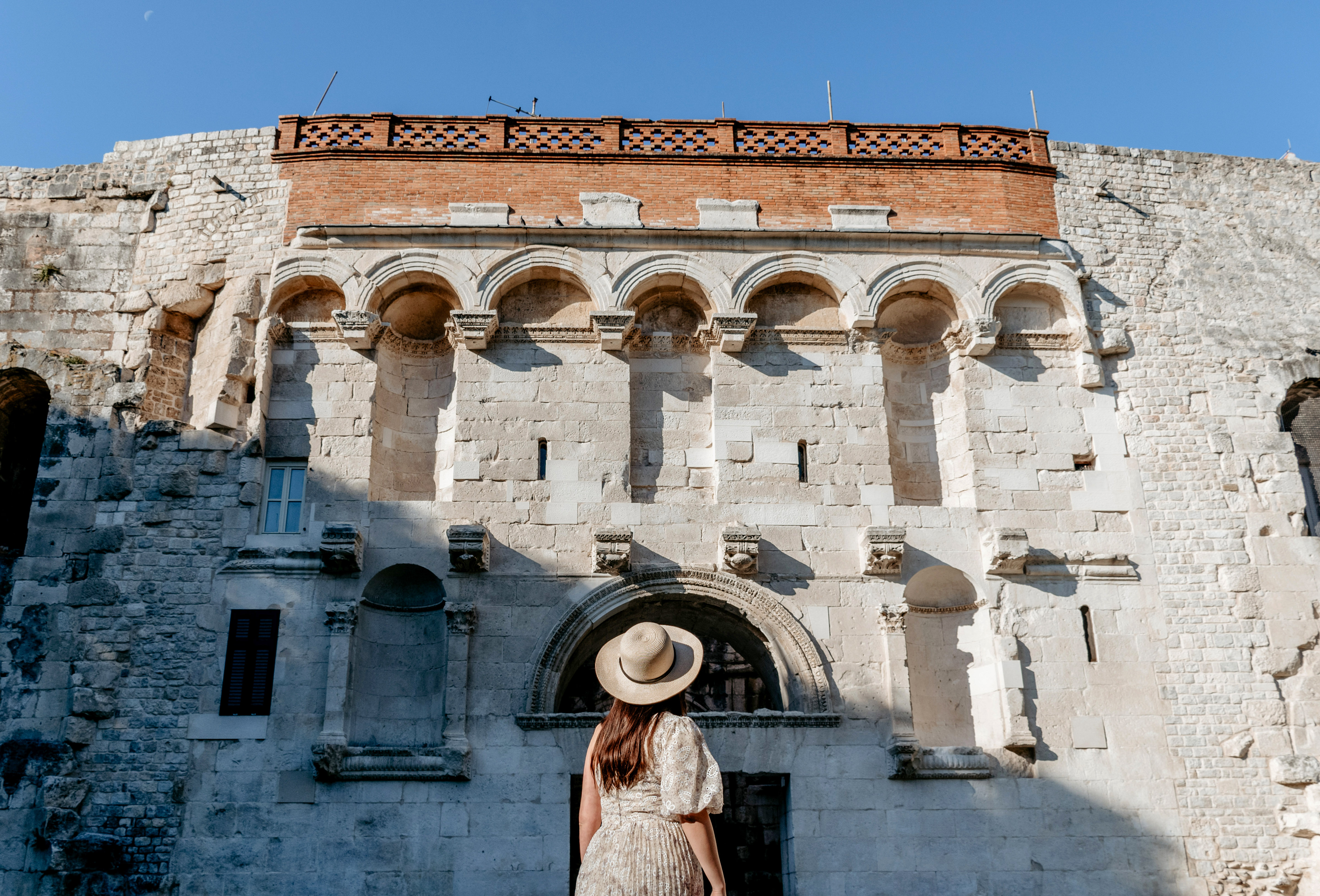 Entrance to Diocletian's Palace in Split, Croatia with tourists exploring the ancient stone archway.