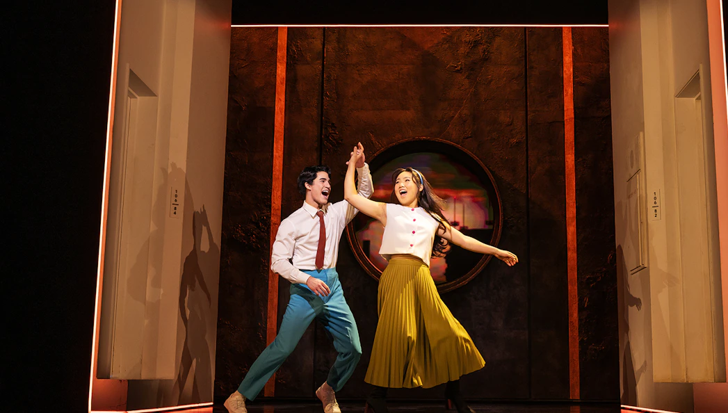 Performers dancing joyfully on stage during "Maybe Happy Ending" show.