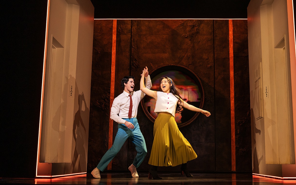 Performers dancing joyfully on stage during "Maybe Happy Ending" show.