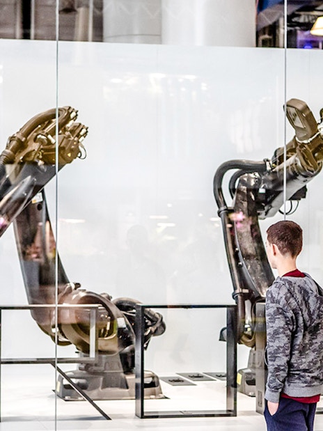 Children observing robotic arms exhibit at Science & Industry Museum, Paris, France.
