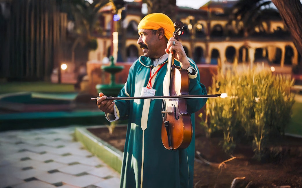 Musician playing violin at Chez Ali Dinner & Fantasia Show in Marrakech.