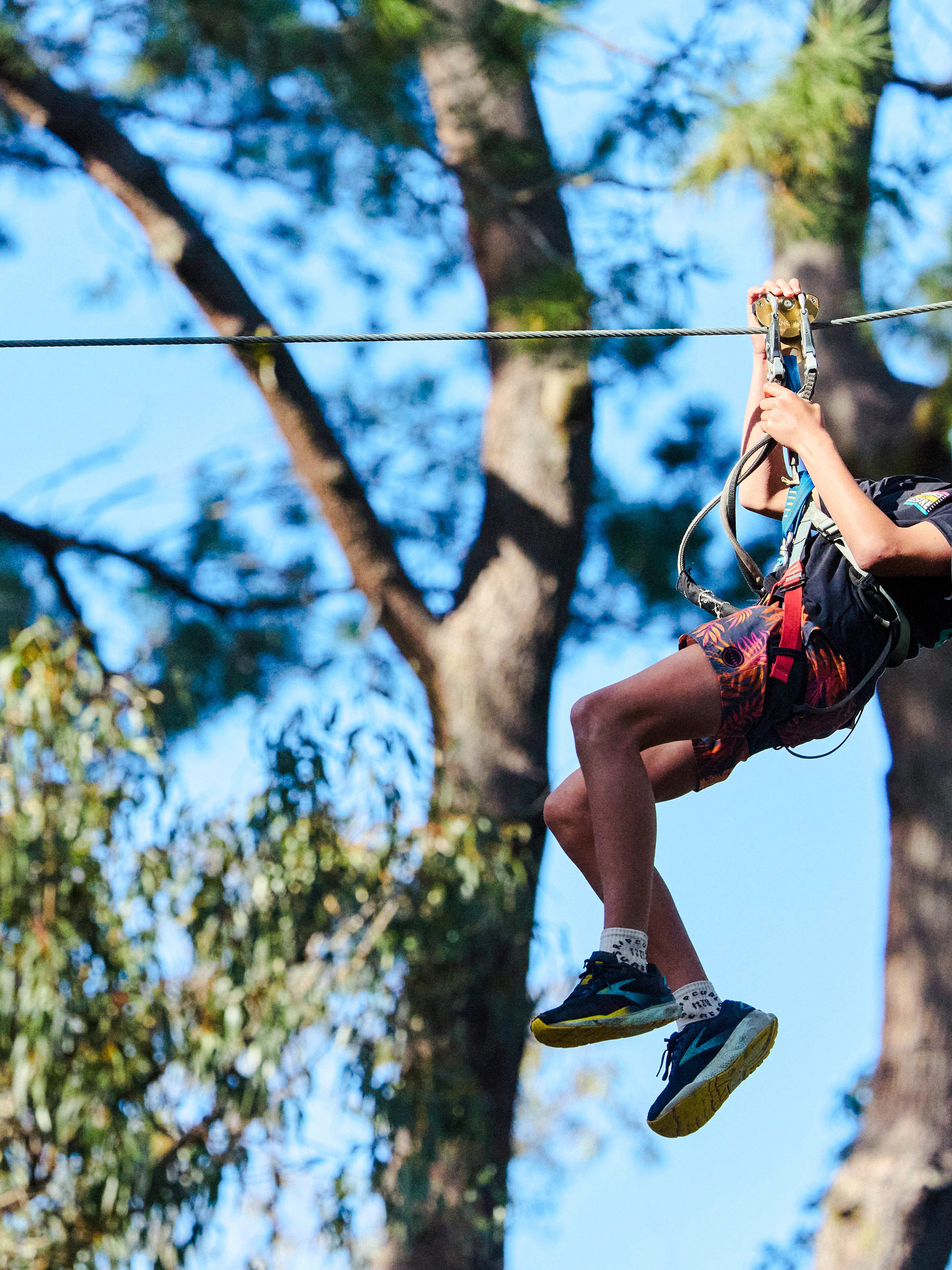 Participant ziplining at Busselton Forest Adventures High Ropes Course.