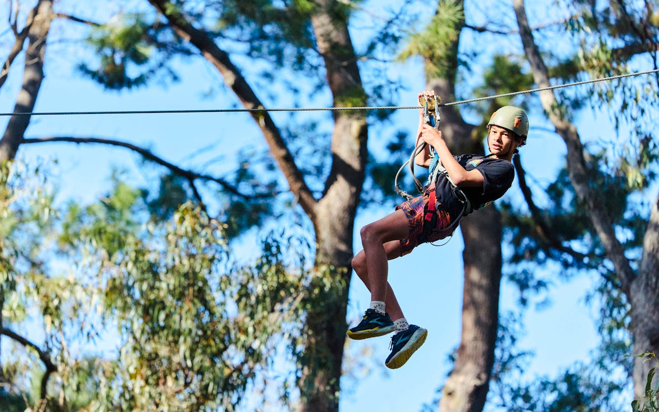 Participant ziplining at Busselton Forest Adventures High Ropes Course.