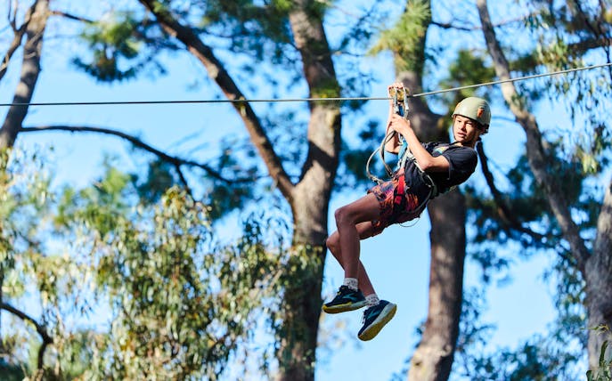 Participant ziplining at Busselton Forest Adventures High Ropes Course.