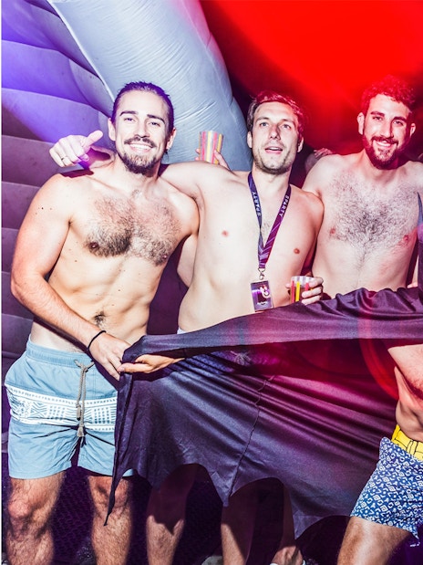 Group of friends enjoying Sparty bath party in Budapest with colorful lights.