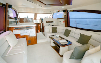 Luxury yacht interior with plush seating and ocean view, Dubai.