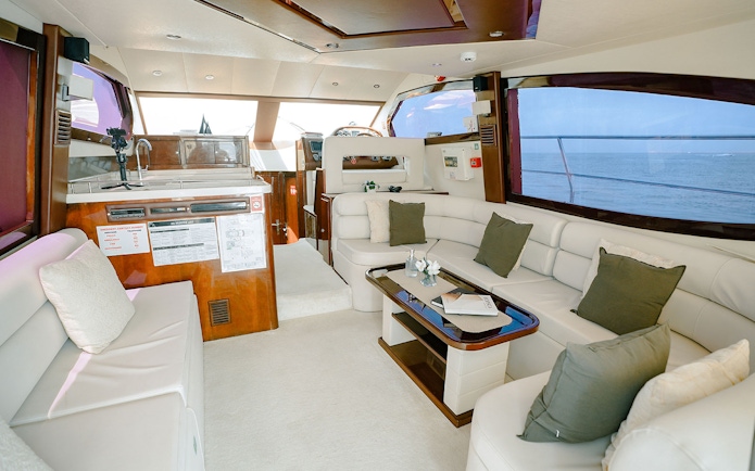 Luxury yacht interior with plush seating and ocean view, Dubai.