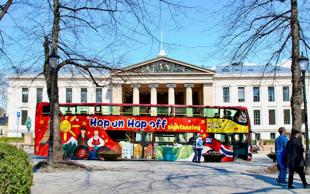 Hop on hop off bus in front of University of Oslo building.