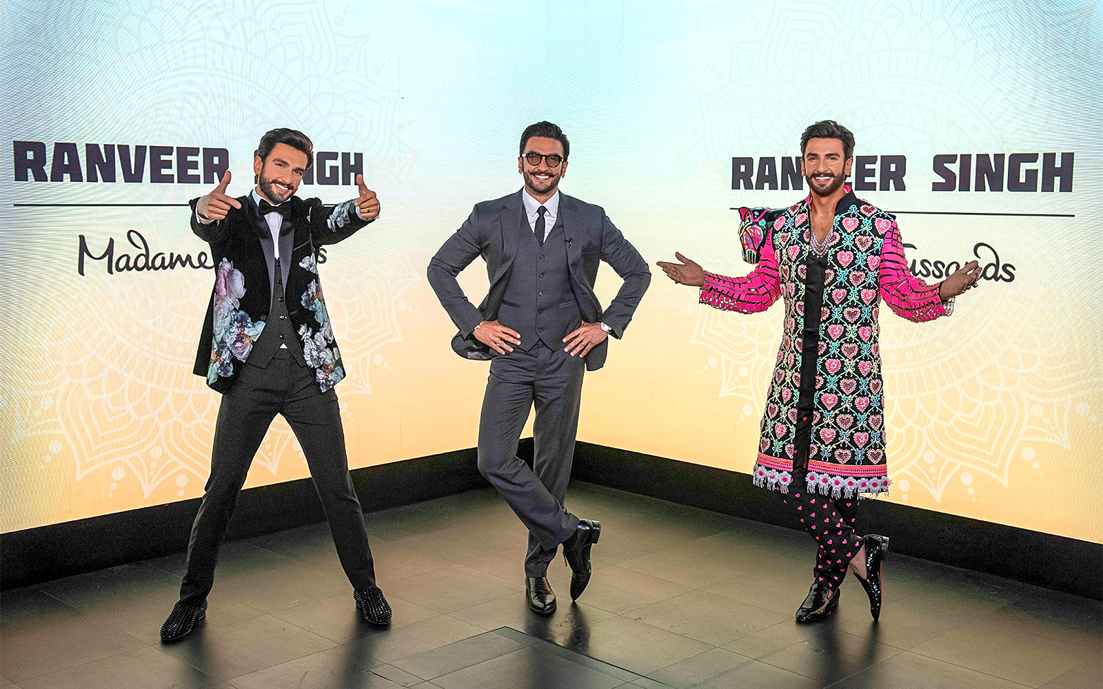 Wax figures of a celebrity in various outfits at Madame Tussauds Singapore.