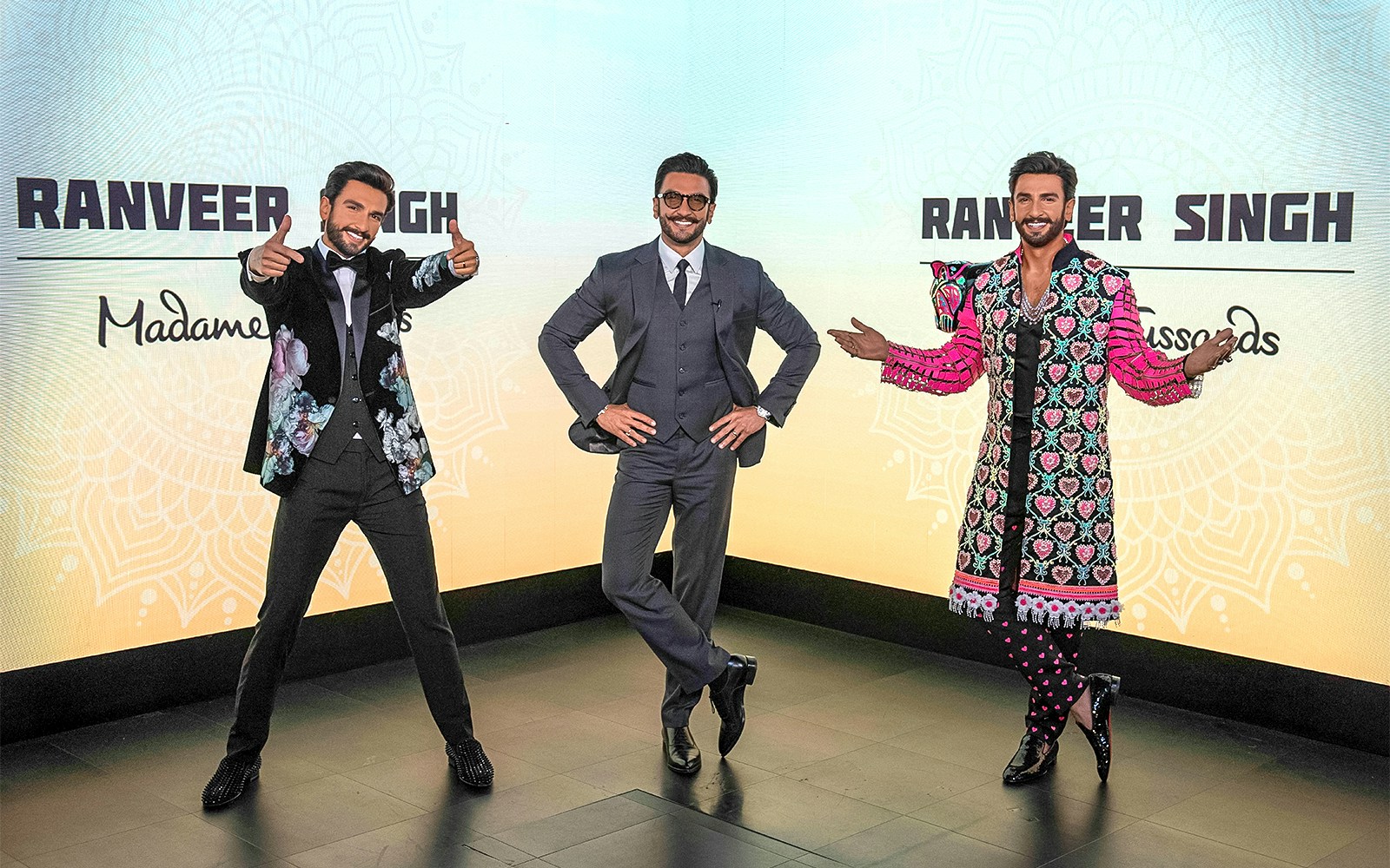 Wax figures of a celebrity in various outfits at Madame Tussauds Singapore.