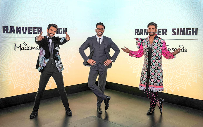 Wax figures of a celebrity in various outfits at Madame Tussauds Singapore.