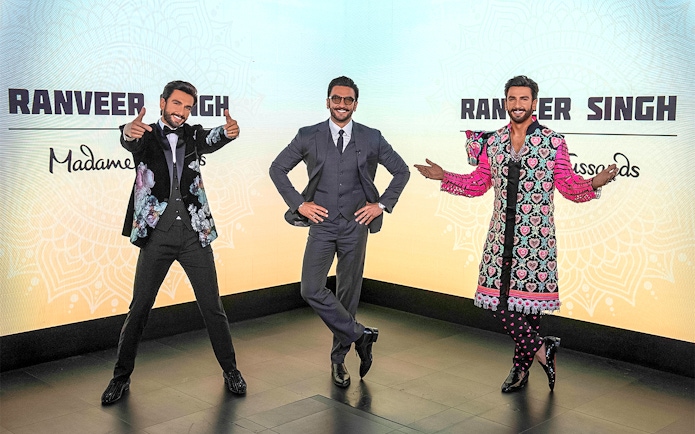 Wax figures of a celebrity in various outfits at Madame Tussauds Singapore.