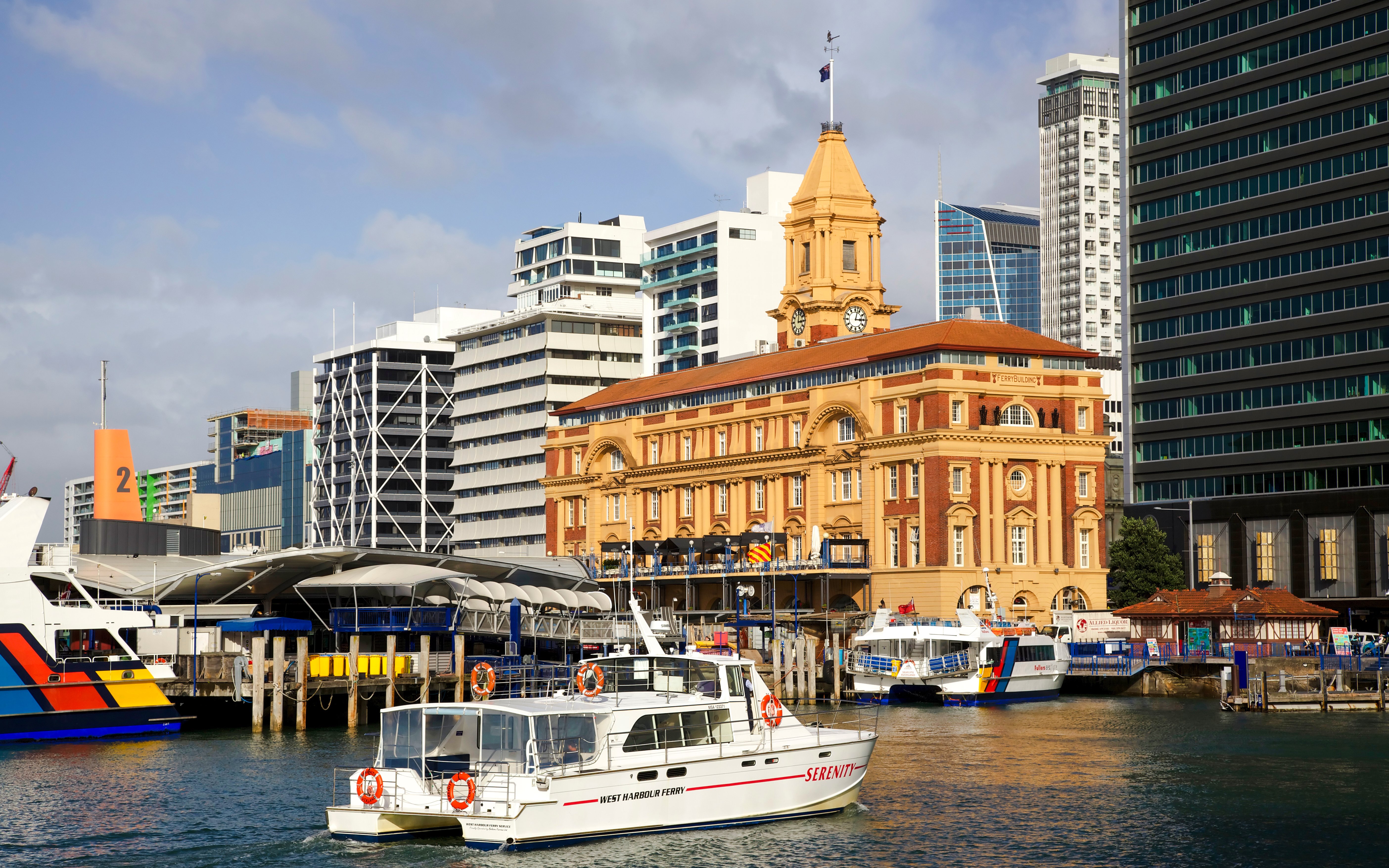Auckland ferry terminal with boats docked, viewed from the harbor.