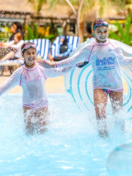 Children enjoying water activities at a Doha water park.