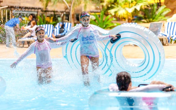 Children enjoying water activities at a Doha water park.