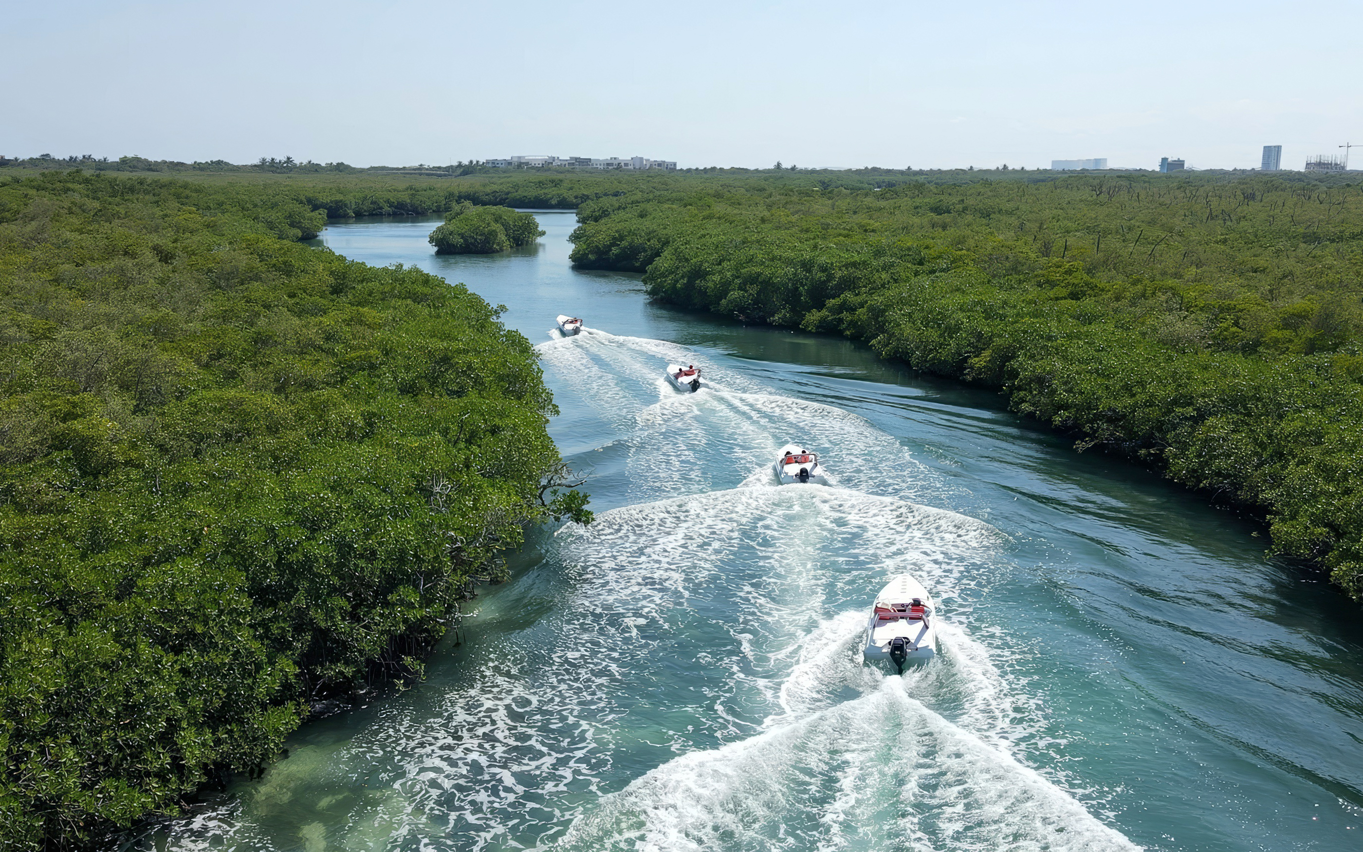 Speedboats navigating through mangroves in Cancun during a snorkel adventure.