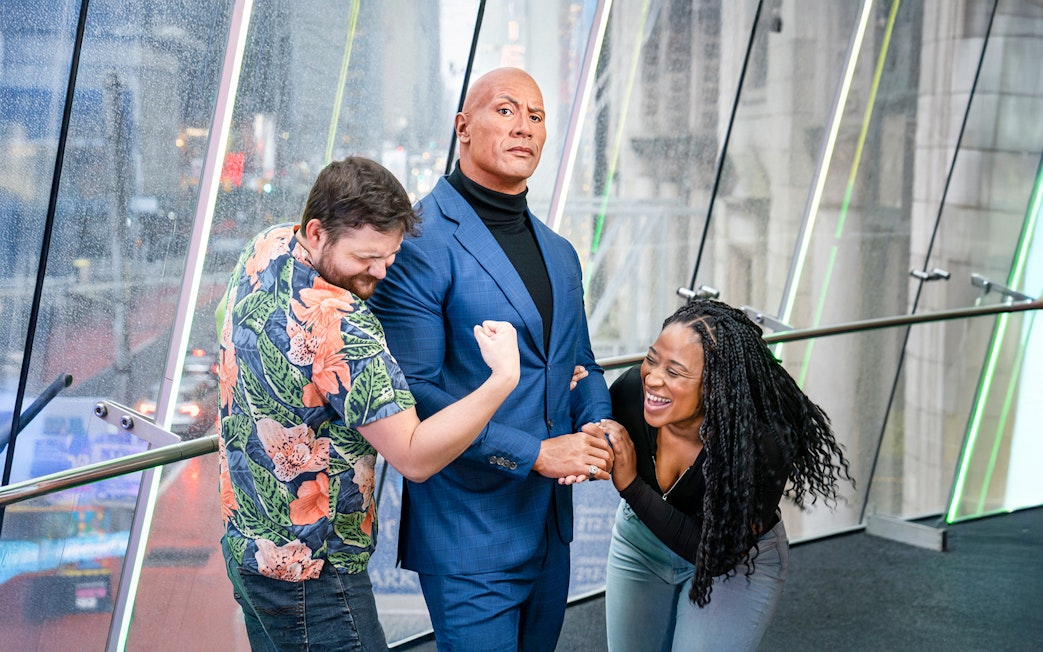 Couple posing with Dwayne Johnson wax figure at Madame Tussauds, New York.