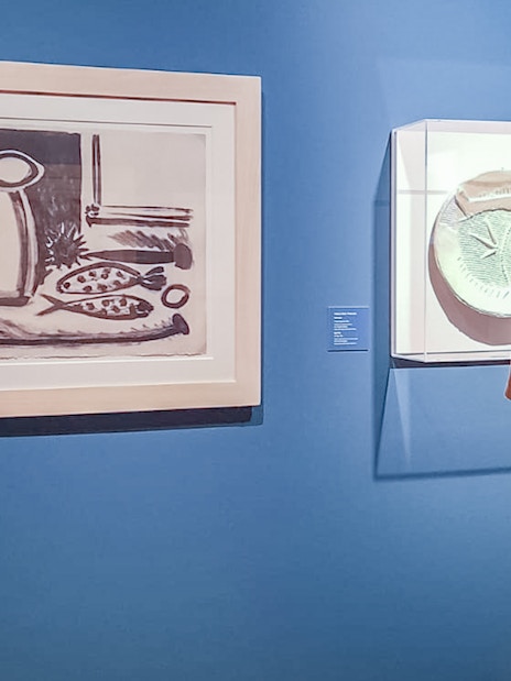 Visitor viewing art pieces in a museum exhibition.