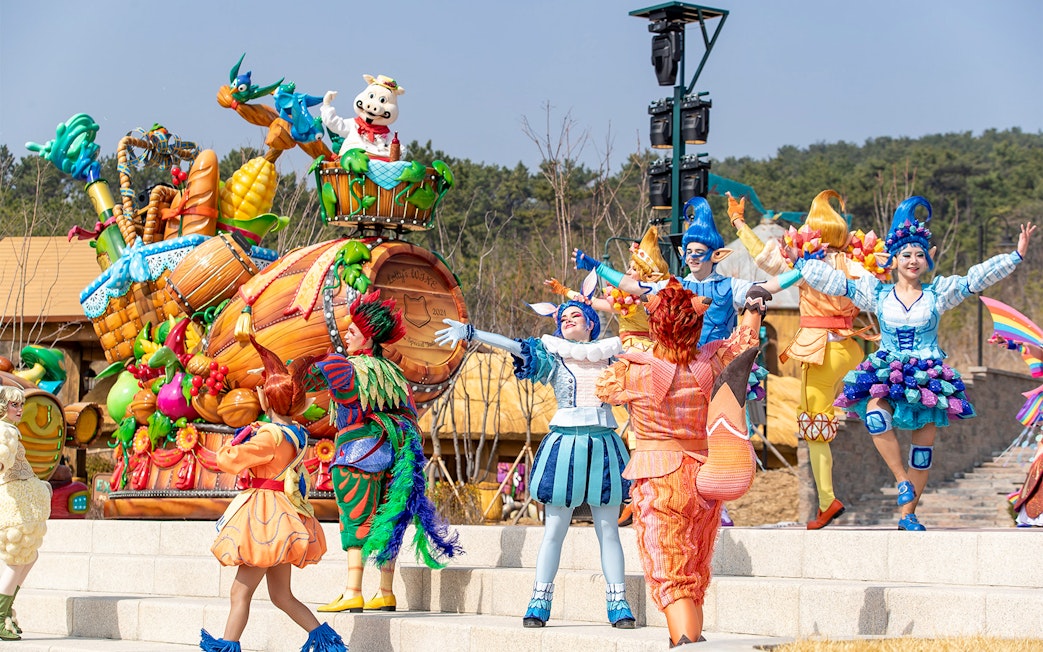 Performers in colorful costumes during a parade at Lotte World Adventure Busan.