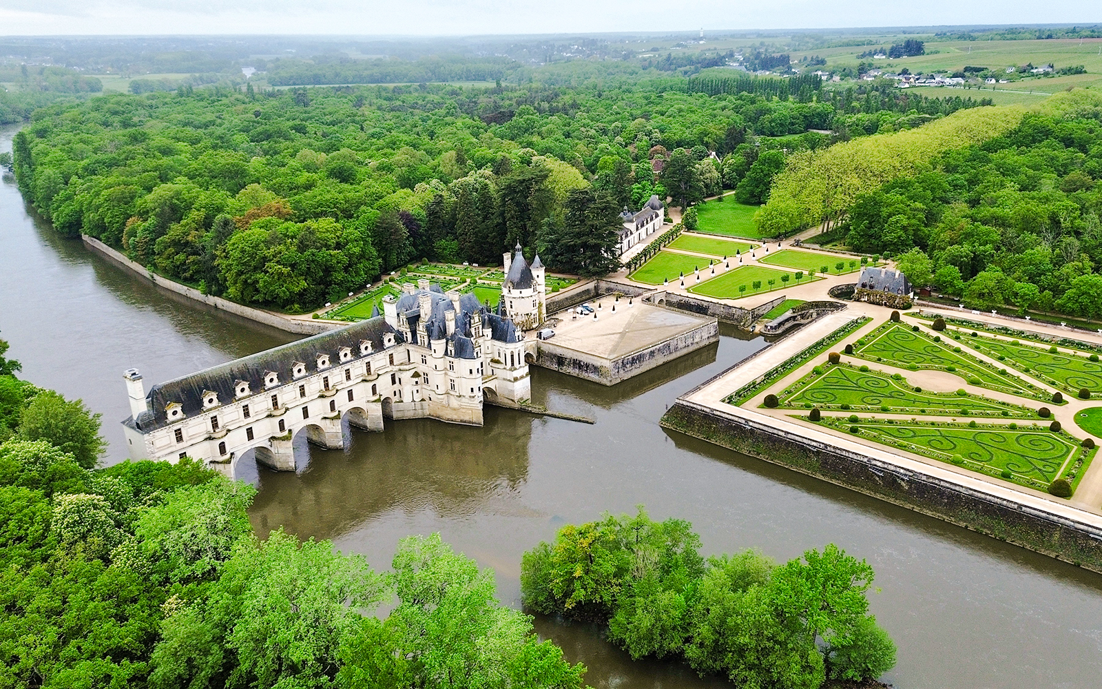 Chenonceau Castle aerial view with gardens and river in Loire Valley, France.