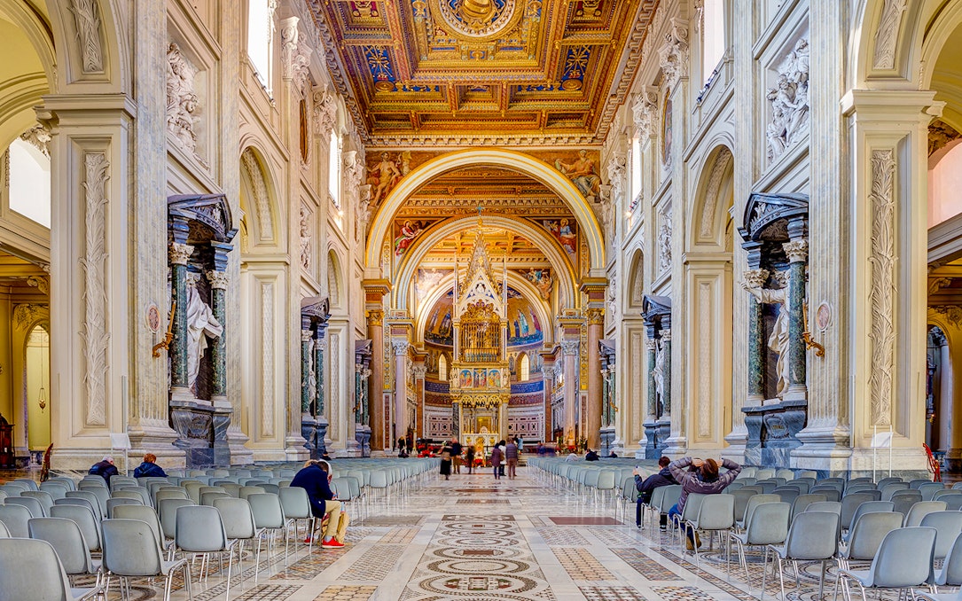 Interior view of the Basilica of Saint John in Lateran with ornate ceiling and statues.