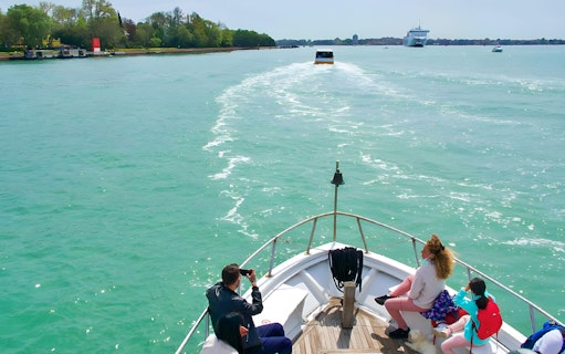 Boat passengers enjoying a scenic ride towards Venice, Italy.
