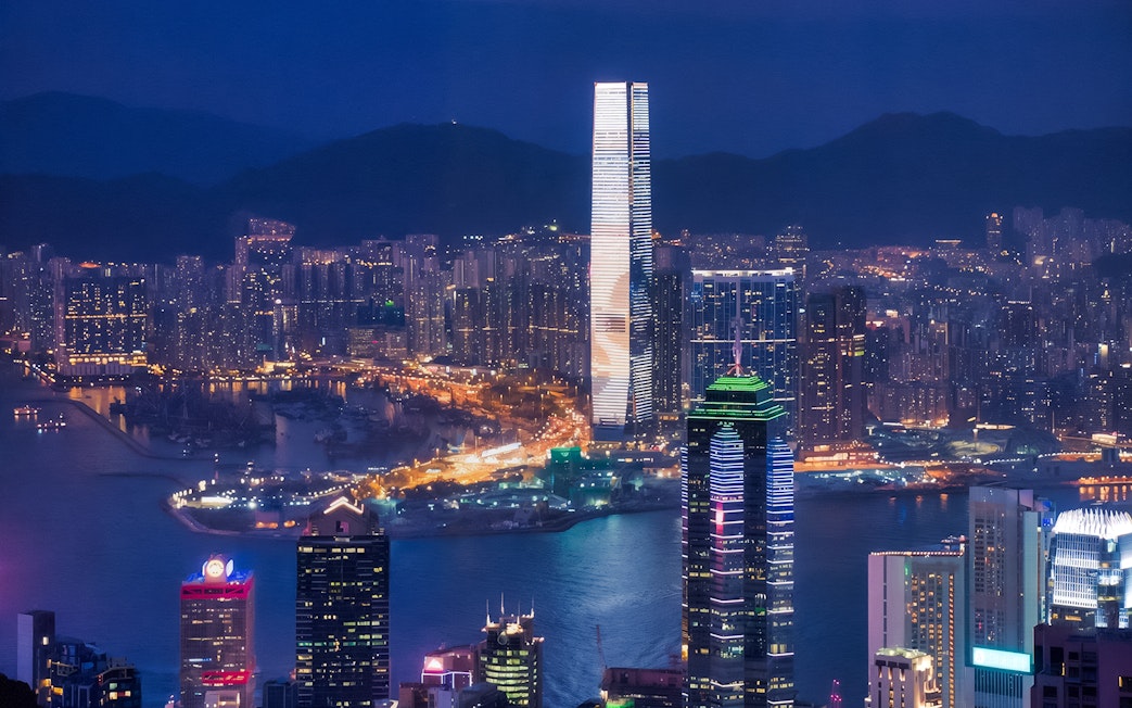 Hong Kong skyline at night viewed from TurboJET Ferry, with illuminated skyscrapers.