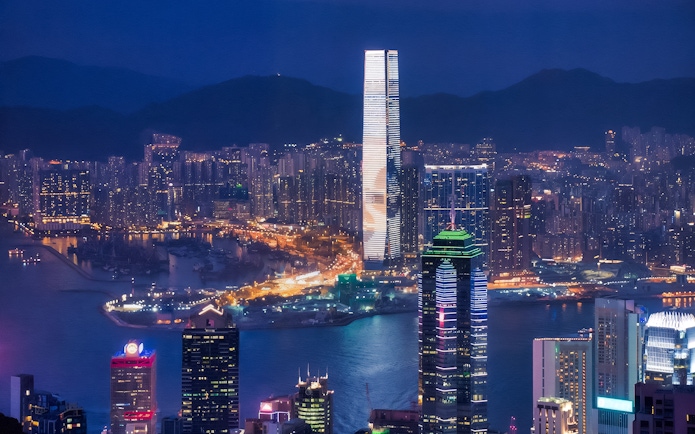 Hong Kong skyline at night viewed from TurboJET Ferry, with illuminated skyscrapers.