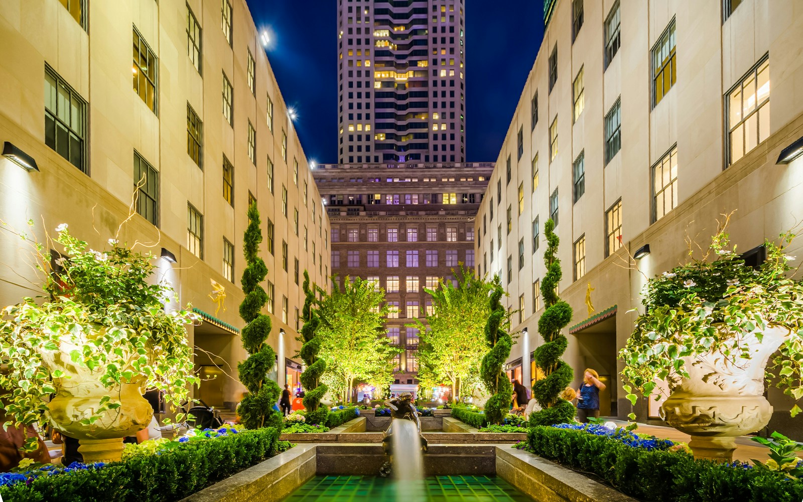 Channel Gardens at Rockefeller Center, New York City, illuminated at night with fountains and greenery.