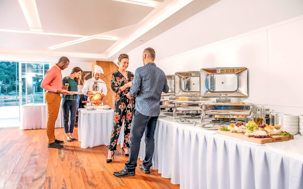 Guests enjoying buffet on Prague dinner cruise with live music.