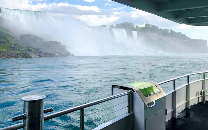 Boat view approaching Niagara Falls USA with mist and cascading water.