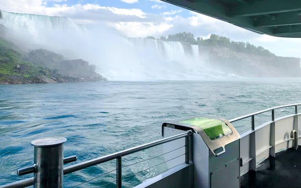 Boat view approaching Niagara Falls USA with mist and cascading water.