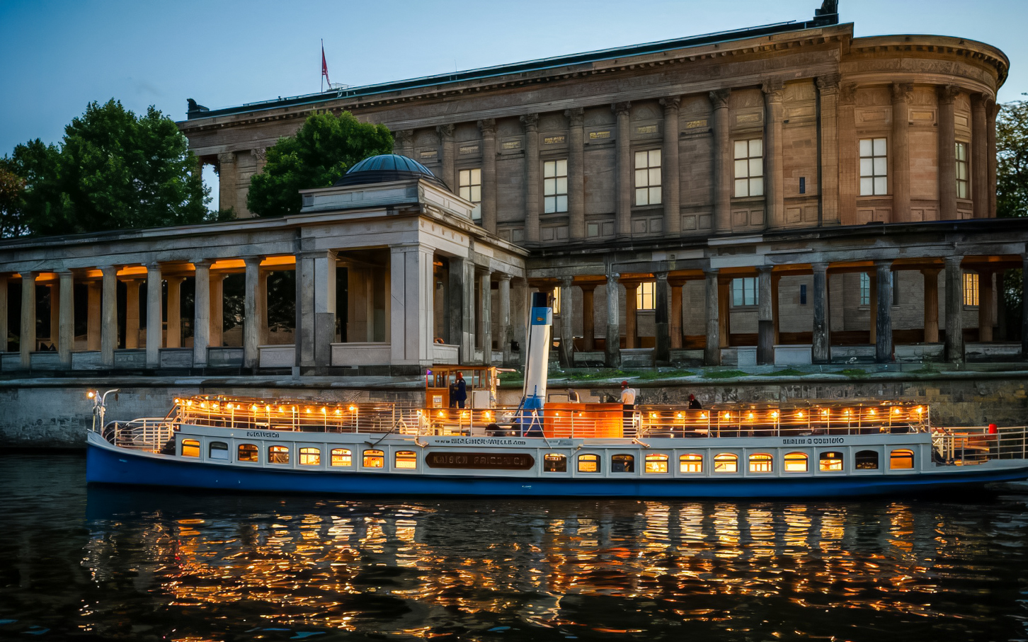 Evening cruise boat illuminated near Museum Island, Berlin.