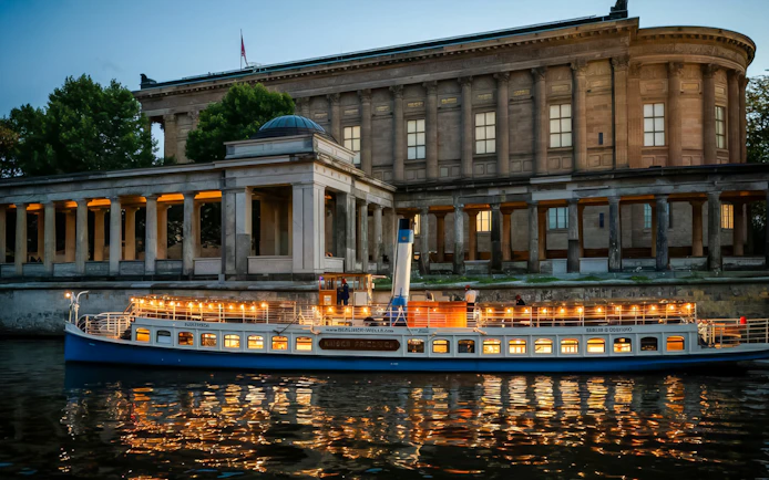 Evening cruise boat illuminated near Museum Island, Berlin.