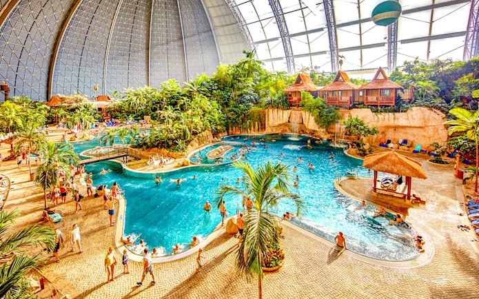 Indoor water park with pools and tropical plants at Tropical Islands Resort.